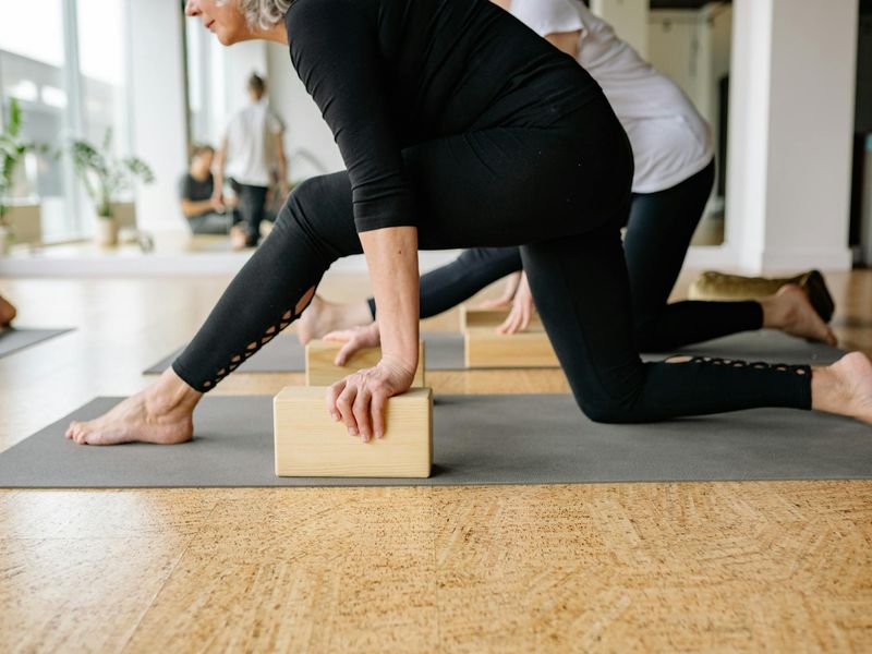 Close up of yoga mats and blocks in a sunlit studio.