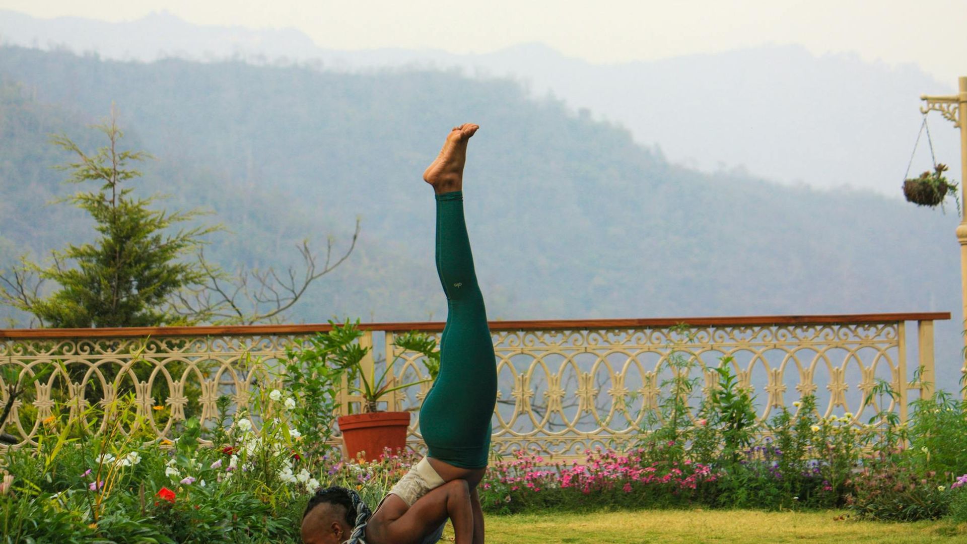 Woman practicing yoga outdoors in a peaceful landscape.